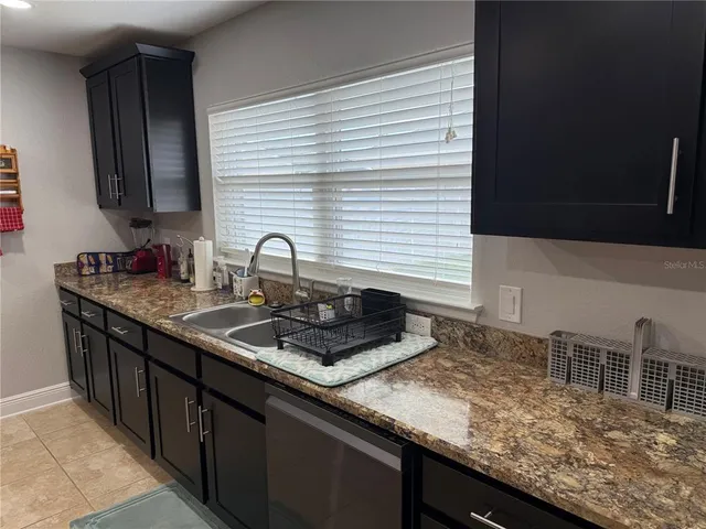 a kitchen with stainless steel appliances kitchen island granite countertop a stove a sink and a refrigerator