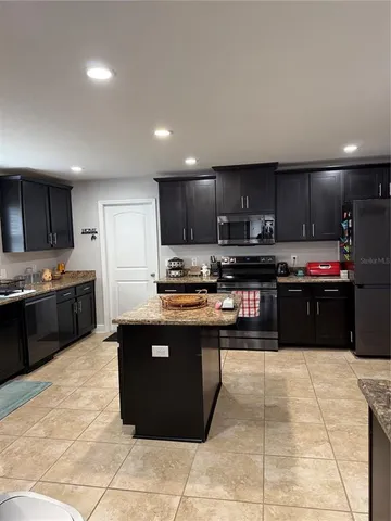 a kitchen with stainless steel appliances granite countertop a stove a refrigerator and a sink