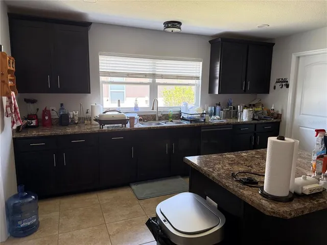 a kitchen with a sink a stove and wooden cabinets