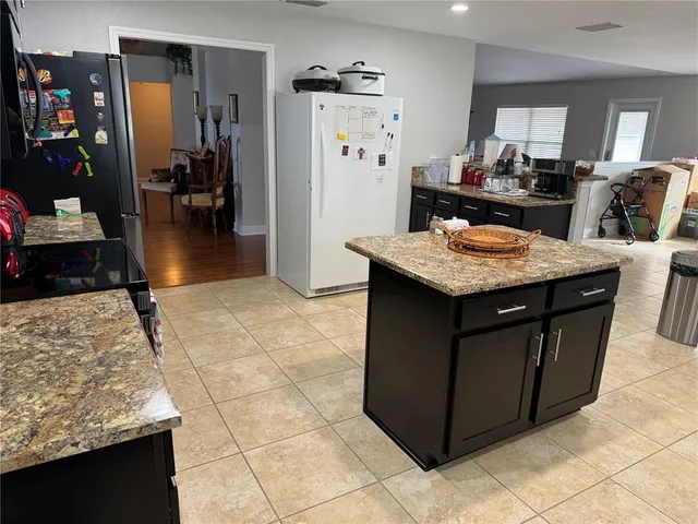 a kitchen with a stove a refrigerator and a dining table