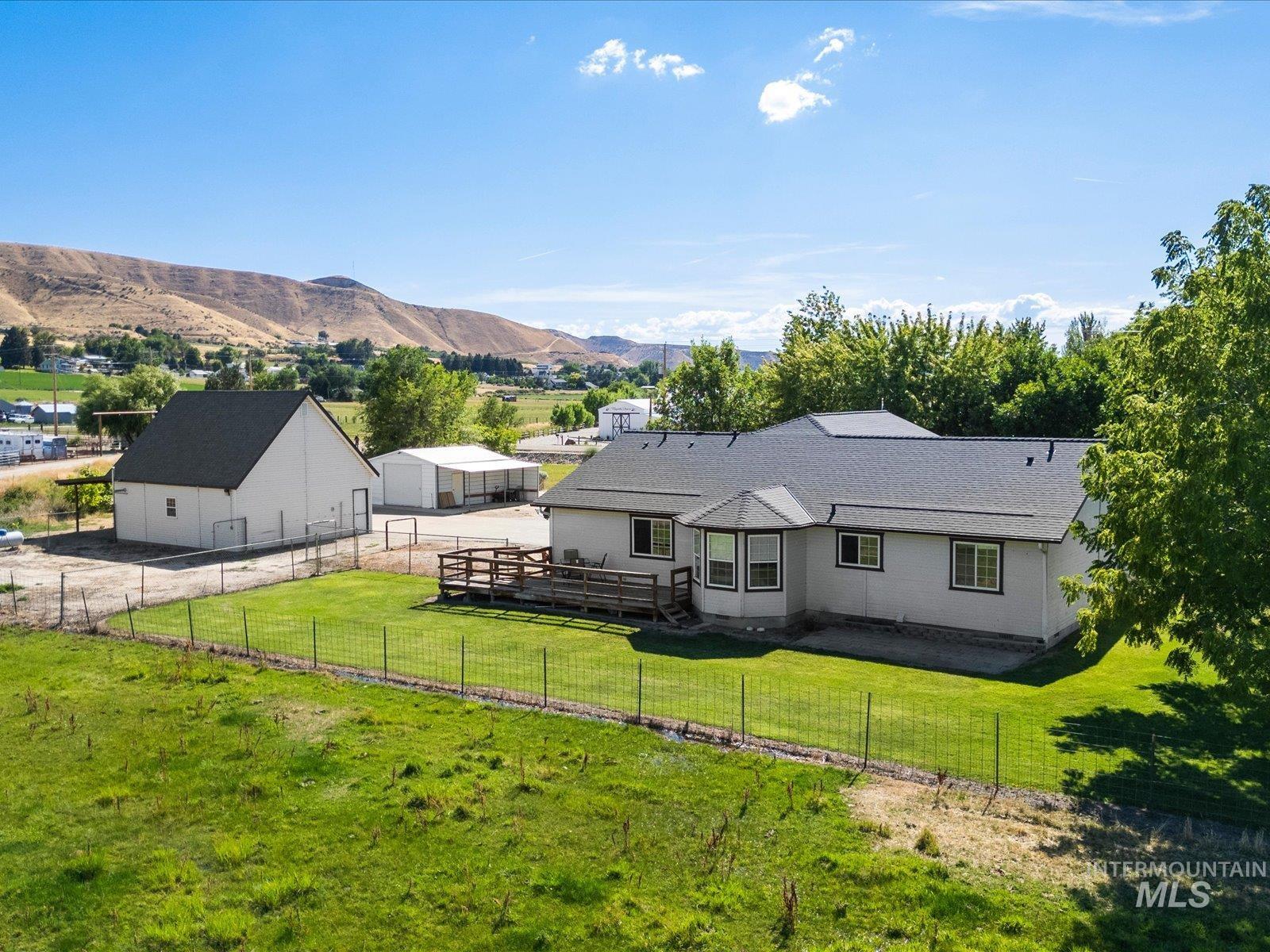 3540 Wills Road Emmett, ID 83617 - Photo 34 of 36 Expansive property featuring a single-story residence with a bay window, a large wood deck, and a detached auxiliary building