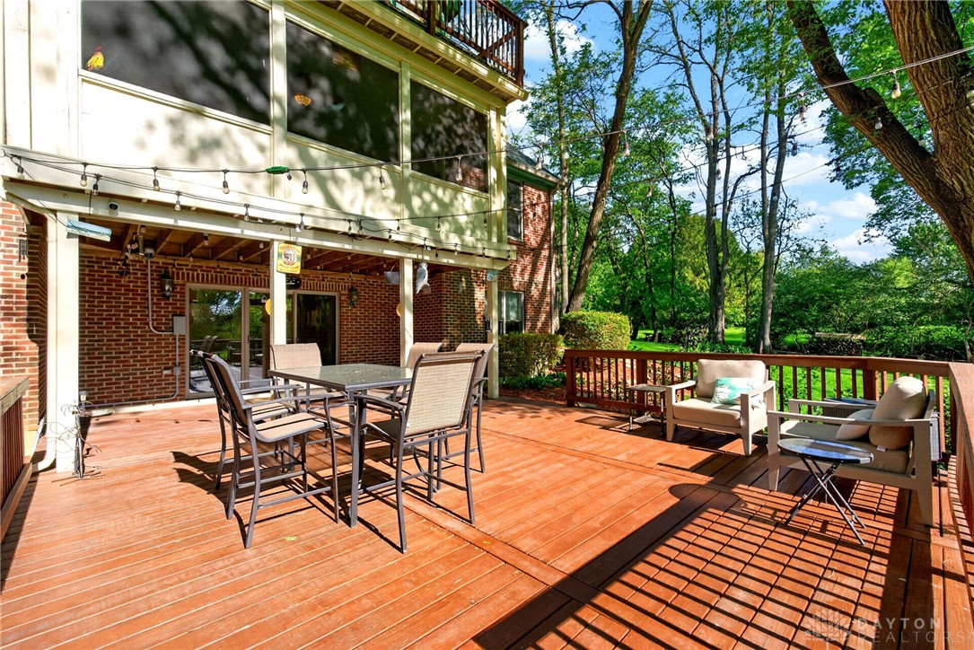 330 South Alpha Bellbrook Road Bellbrook, OH 45305 - Photo 60 of 87 This spacious wooden deck offers abundant space for outdoor relaxation and entertaining amidst lush greenery.