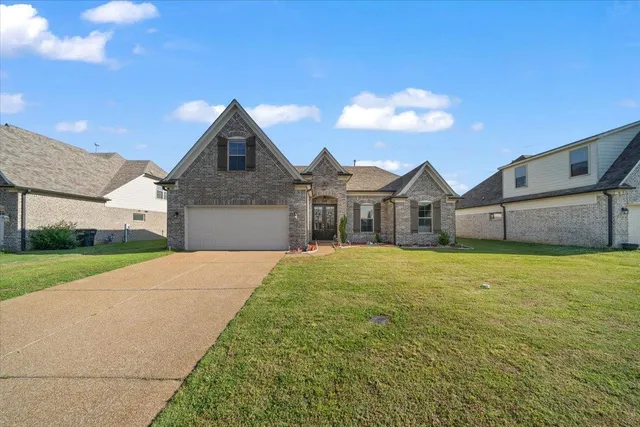 a front view of a house with a yard and garage