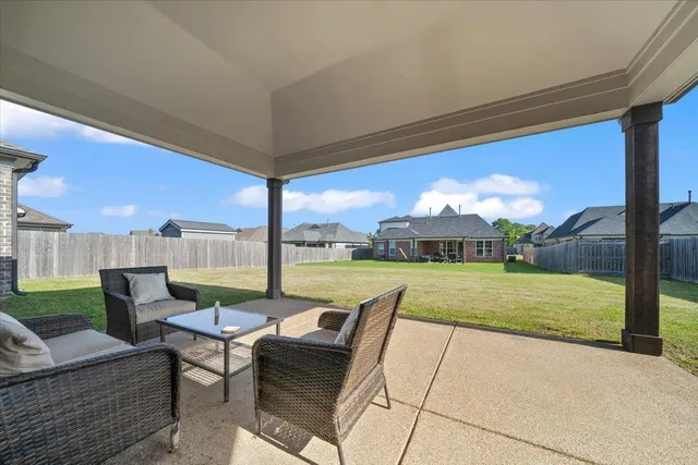 a view of a patio with dining table and chairs under an umbrella