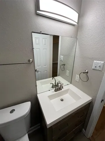 a bathroom with a sink a toilet and mirror