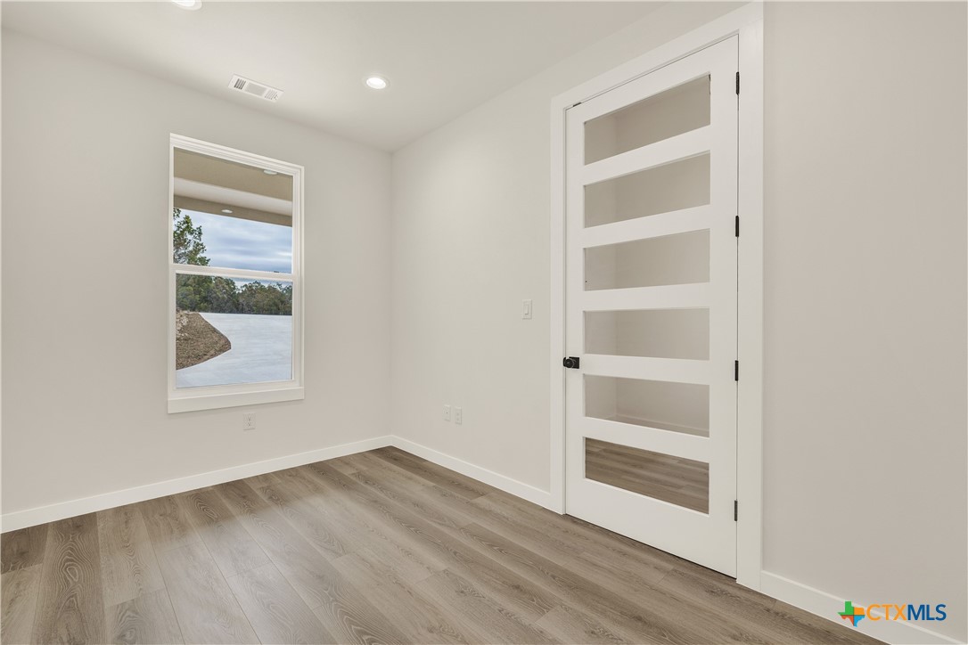 328 Compass Rose Spring Branch, TX 78070 - Photo 7 of 48 a view of an empty room with a window and wooden floor