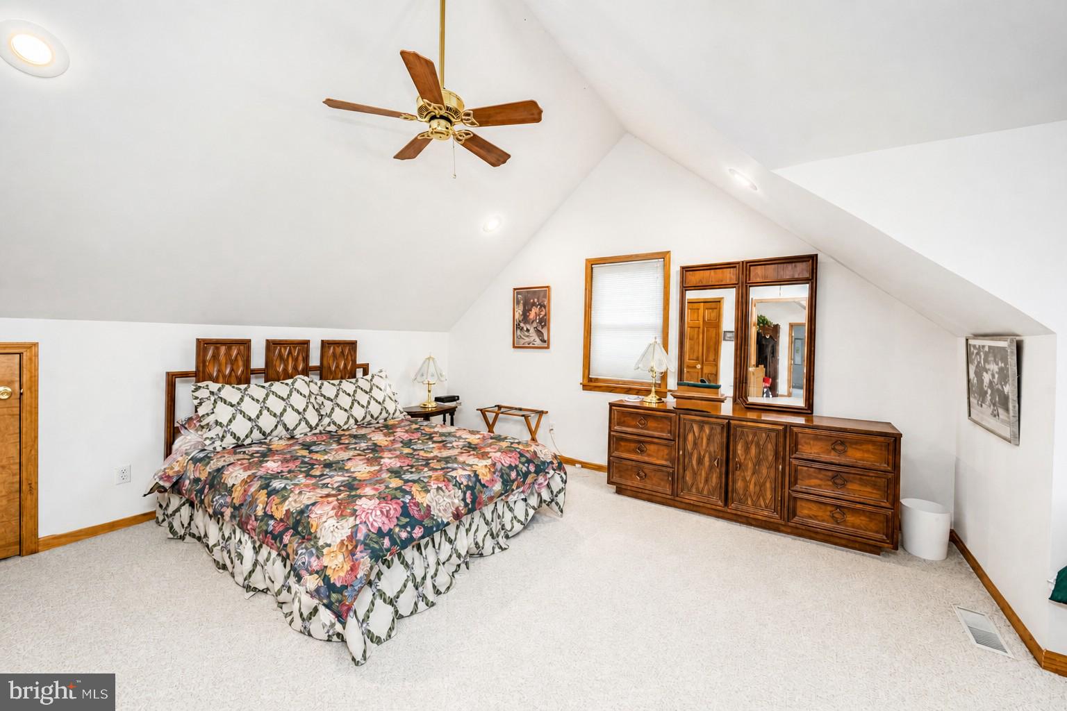 389 Sawmill Hollow Road Swanton, MD 21561 - Photo 31 of 62 a bedroom with a large bed and a chandelier