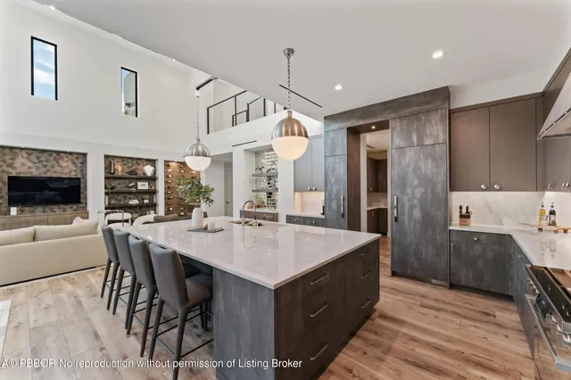 a kitchen with a dining table chairs sink and white cabinets