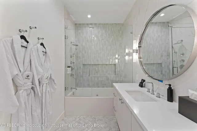 a bathroom with a double vanity sink a toilet a mirror and a bathtub