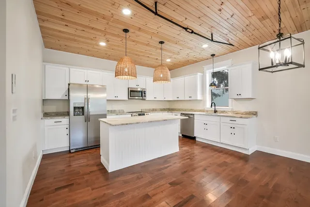 a kitchen with a white wooden cabinets stainless steel appliances and a window