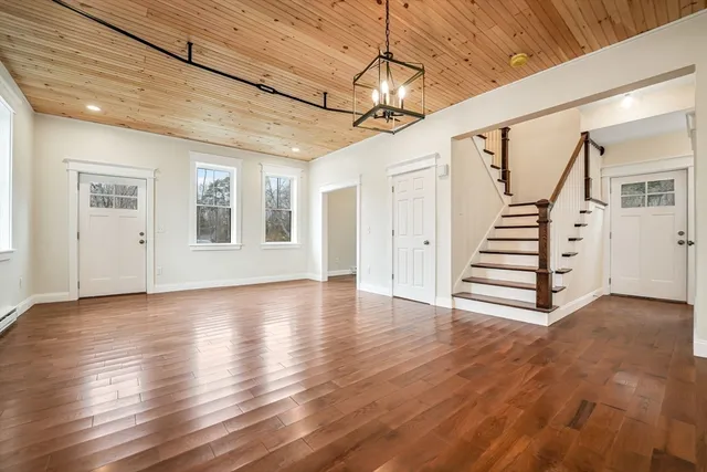 a view of a livingroom with wooden floor and stairs