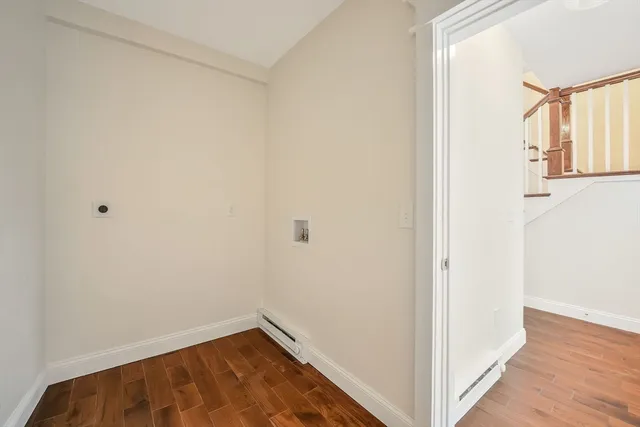 a view of a hallway with wooden floor and a window
