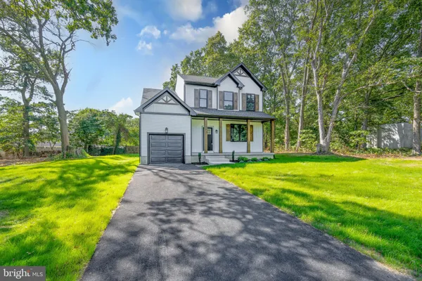 a front view of a house with yard and green space