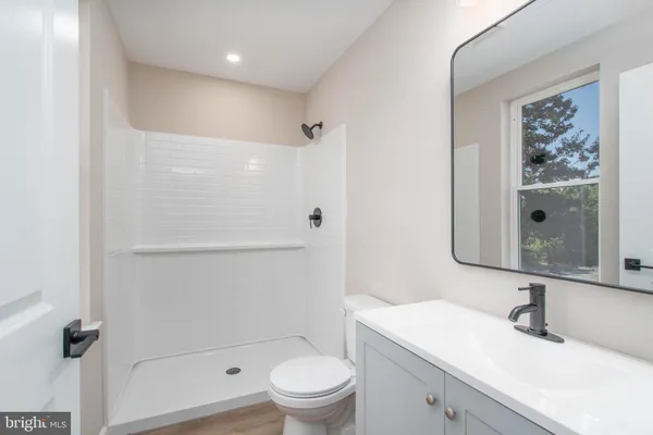 a bathroom with a granite countertop sink a toilet and a mirror