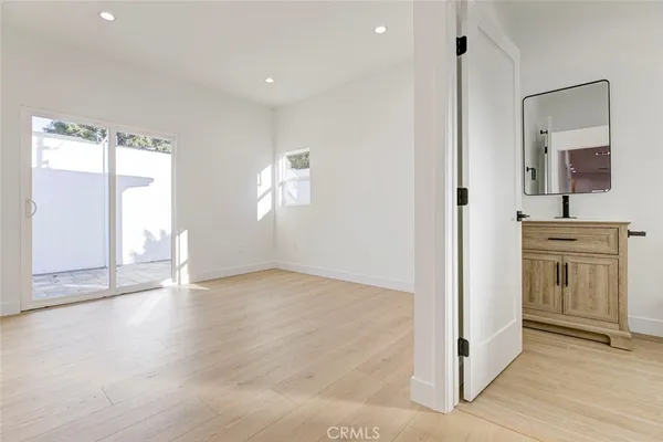 a view of empty room with wooden floor and window