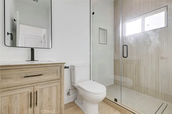 a bathroom with a toilet sink vanity and mirror