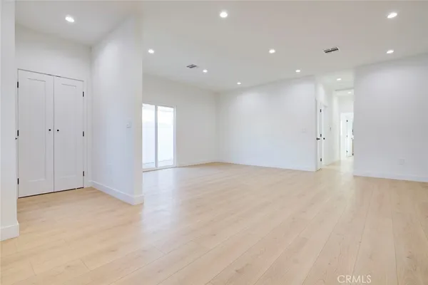 a view of an empty room with wooden floor