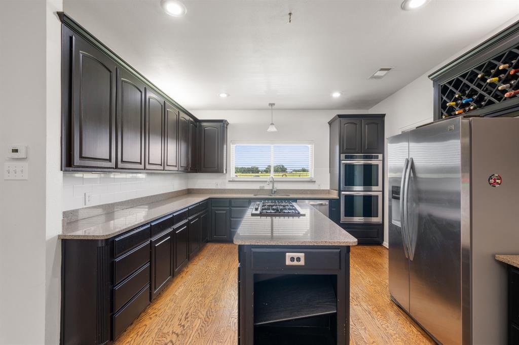 510 South Swanson Road Mineral Wells, TX 76067 - Photo 11 of 38 a kitchen with stainless steel appliances granite countertop a refrigerator a stove and a sink