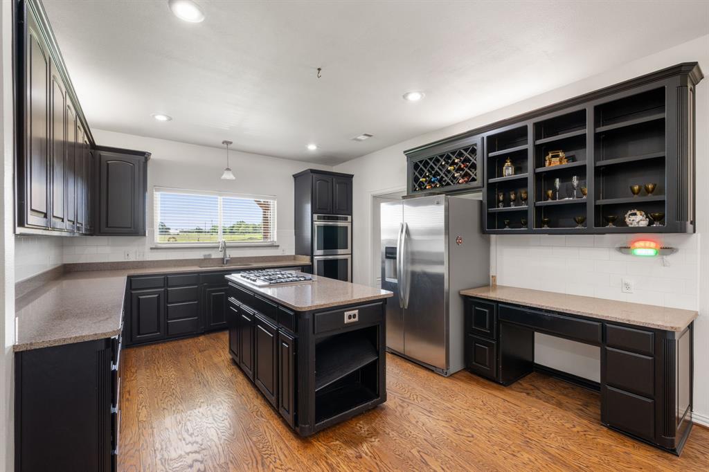 510 South Swanson Road Mineral Wells, TX 76067 - Photo 12 of 38 a kitchen with stainless steel appliances a stove a refrigerator and a sink