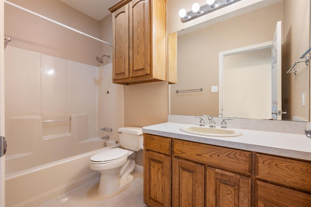 510 South Swanson Road Mineral Wells, TX 76067 - Photo 22 of 38 a bathroom with a granite countertop sink toilet a mirror and shower
