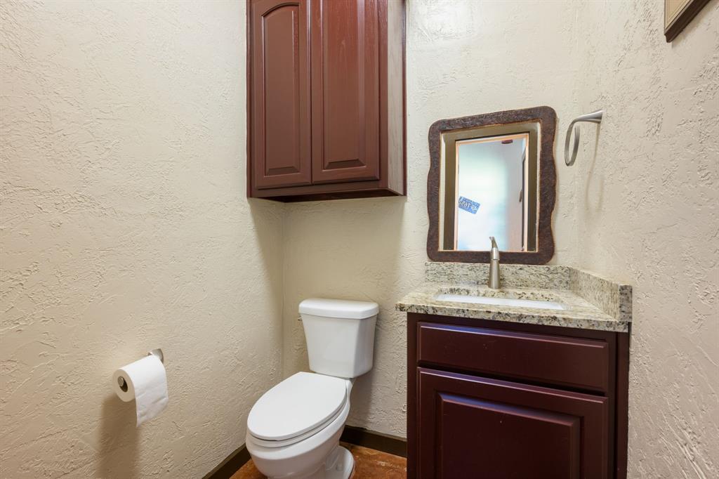 510 South Swanson Road Mineral Wells, TX 76067 - Photo 28 of 38 a bathroom with a toilet sink and mirror