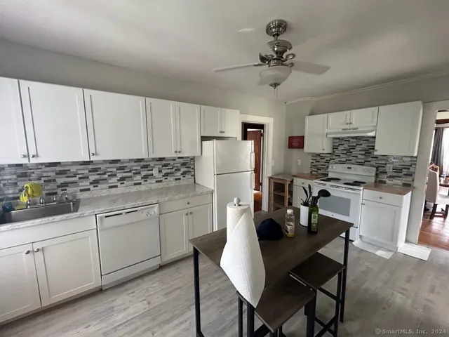 a kitchen with white cabinets refrigerator and stove