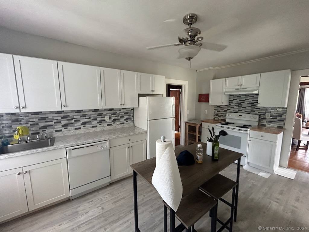 a kitchen with white cabinets refrigerator and stove