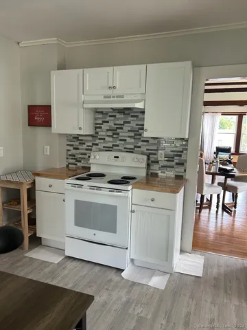 a kitchen with stainless steel appliances white cabinets and a stove top oven