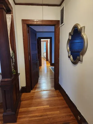 a view of a hallway with wooden floor and stairs