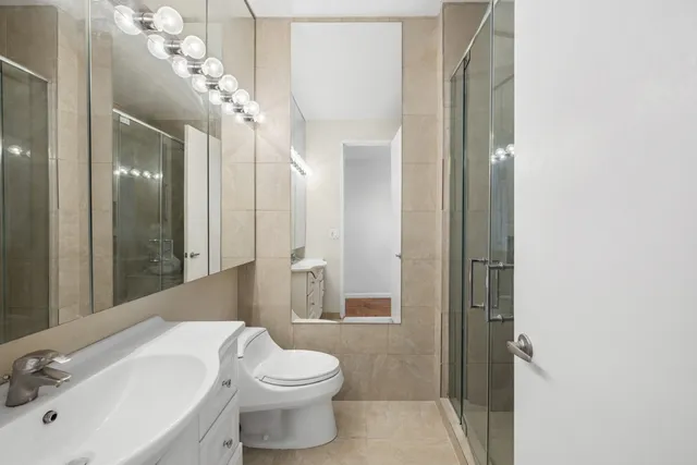 a bathroom with a toilet a sink and a large mirror