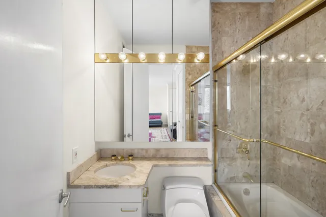 a bathroom with a granite countertop sink a mirror and a shower