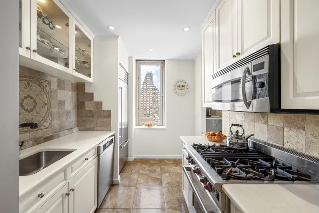 a kitchen with stainless steel appliances a stove a sink and a refrigerator