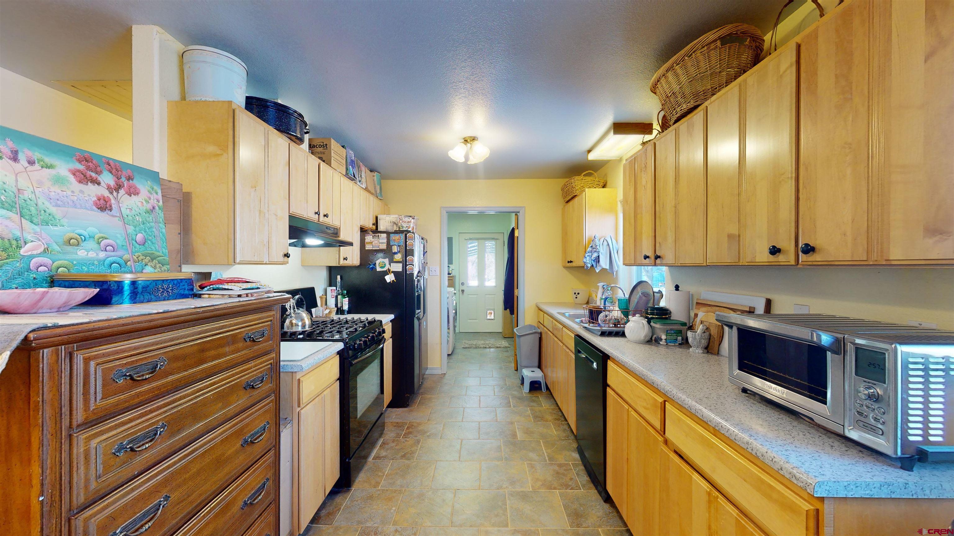 16459 Grange Road Paonia, CO 81428 - Photo 19 of 35 a kitchen with stainless steel appliances granite countertop a stove a sink and a refrigerator