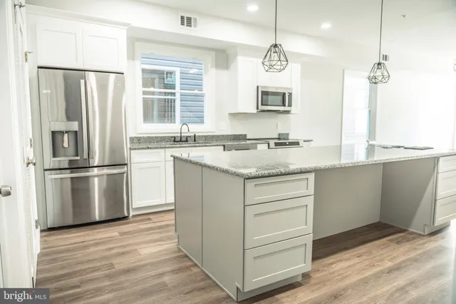 a bathroom with a granite countertop toilet a sink and a bathtub