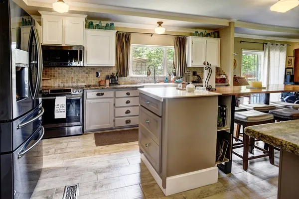 a kitchen with kitchen island a sink stove and refrigerator
