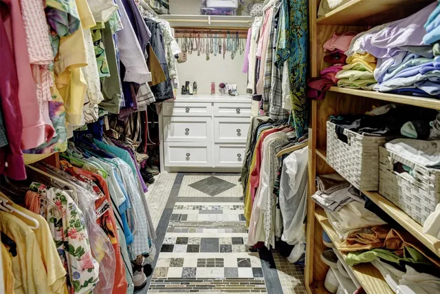 a view of walk in closet with clothes and shoes