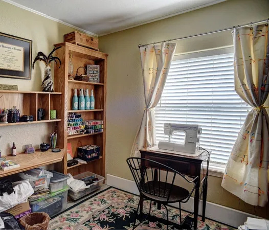 a view of a workspace with furniture and a window