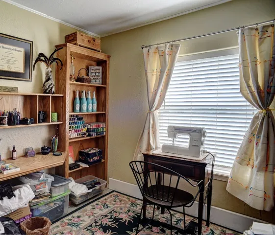 a view of a workspace with furniture and a window