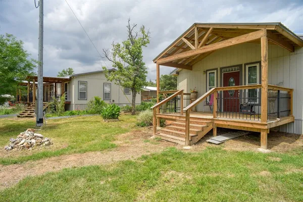a view of a house with a yard and wooden fence