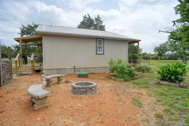 a backyard of a house with table and chairs