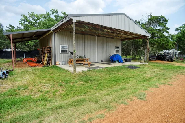 a view of a backyard with table and chairs under an umbrella