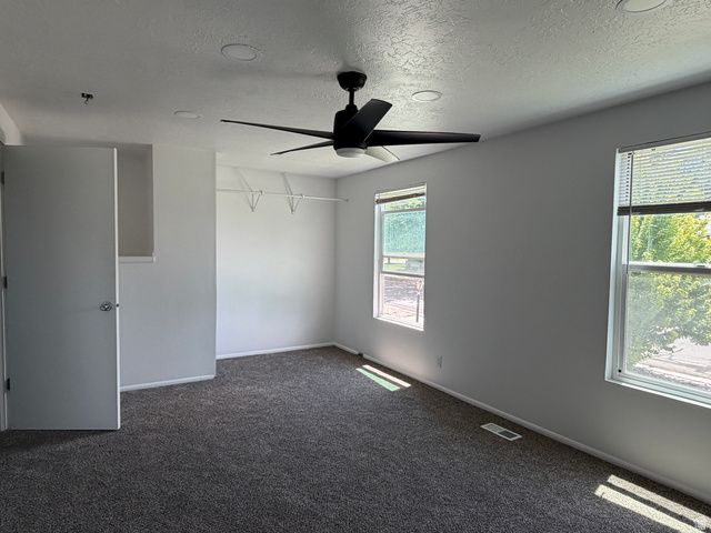 375 East 10560 South Sandy, UT 84070 - Photo 6 of 21 Spacious room featuring neutral carpeting, a modern ceiling fan, recessed lighting, and dual windows providing natural illumination
