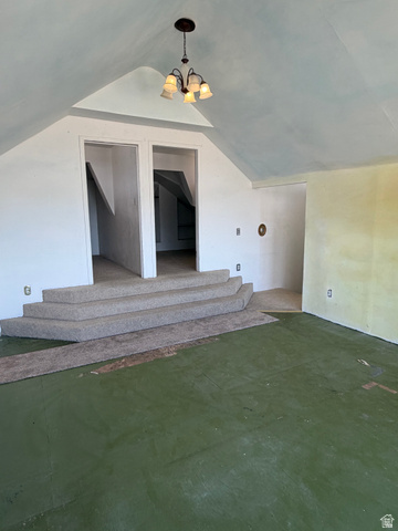 255 E Centre Spring City, UT 84662 - Photo 22 of 34 Attic space featuring a sloped ceiling, central chandelier, two stepped entrances, and green painted flooring