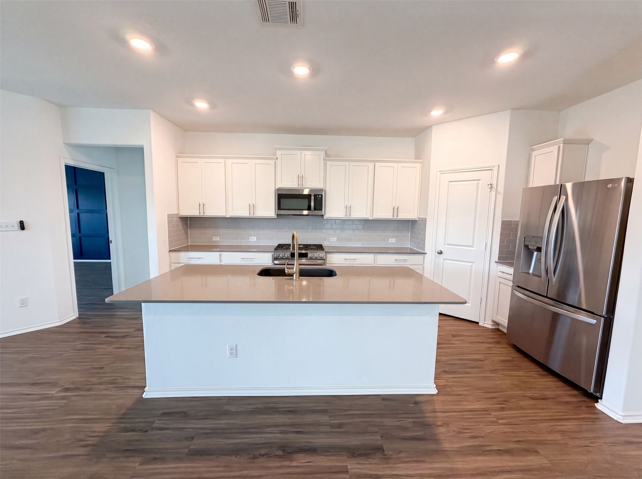 424 Wolf Springs Road Georgetown, TX 78628 - Photo 6 of 15 A contemporary kitchen showcases a generous island, sleek stainless steel appliances, and abundant cabinet space.