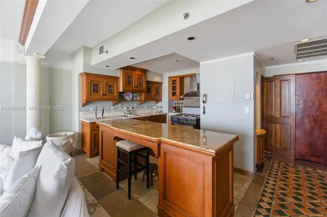 a room with stainless steel appliances kitchen island granite countertop furniture and a sink