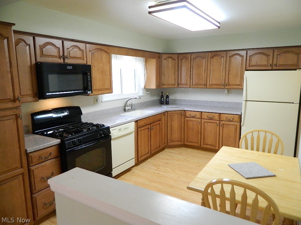 34505 Pettibone Road Solon, OH 44139 - Photo 7 of 32 Updated Dine In Kitchen with Corian Counters, Maple Cabinetry, All Appliances, Laminate Flooring and Window Overlooking the Back Yard!