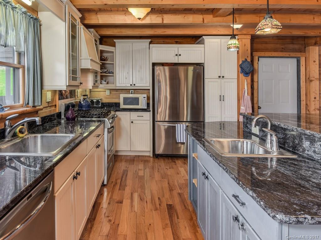 755 Poplar Cove Road Clyde, NC 28721 - Photo 5 of 24 a kitchen with granite countertop a sink stove and refrigerator