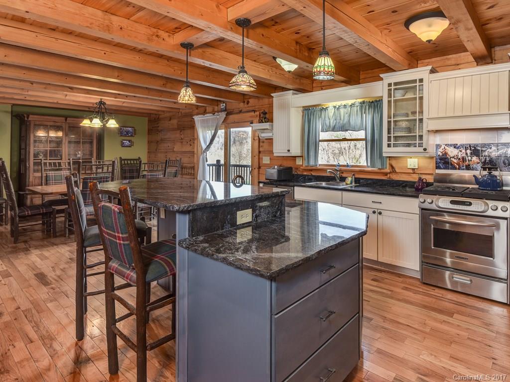 755 Poplar Cove Road Clyde, NC 28721 - Photo 6 of 24 a kitchen with stainless steel appliances granite countertop a stove a sink and a wooden cabinets