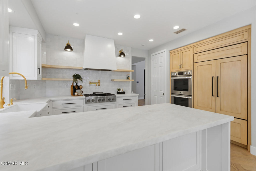 4630 Rio Bravo Court Moorpark, CA 93021 - Photo 11 of 43 a large kitchen with stainless steel appliances a large counter top a stove a refrigerator and a sink