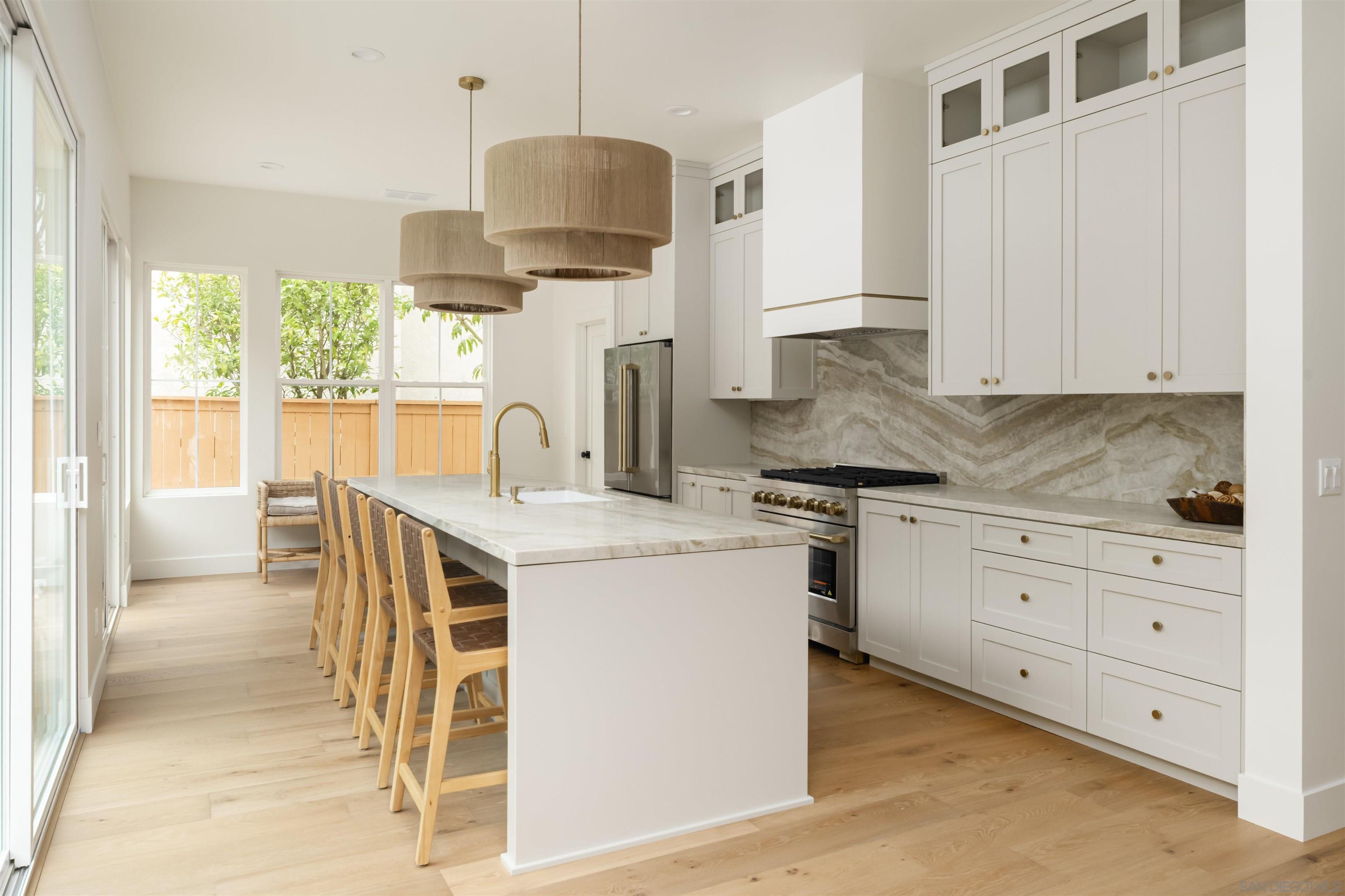 5077 Ashberry Road Carlsbad, CA 92008 - Photo 13 of 35 a kitchen with a stove a sink a center island and cabinets